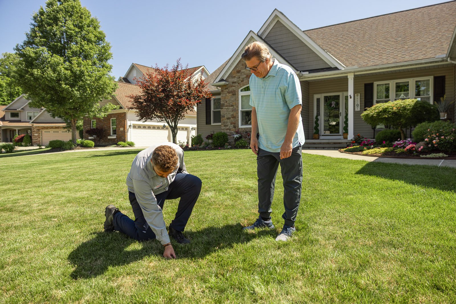 crew and customer looking at grass green