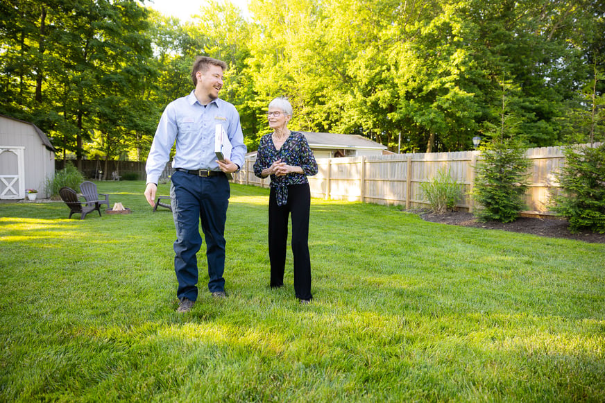 lawn care technician with customer in yard