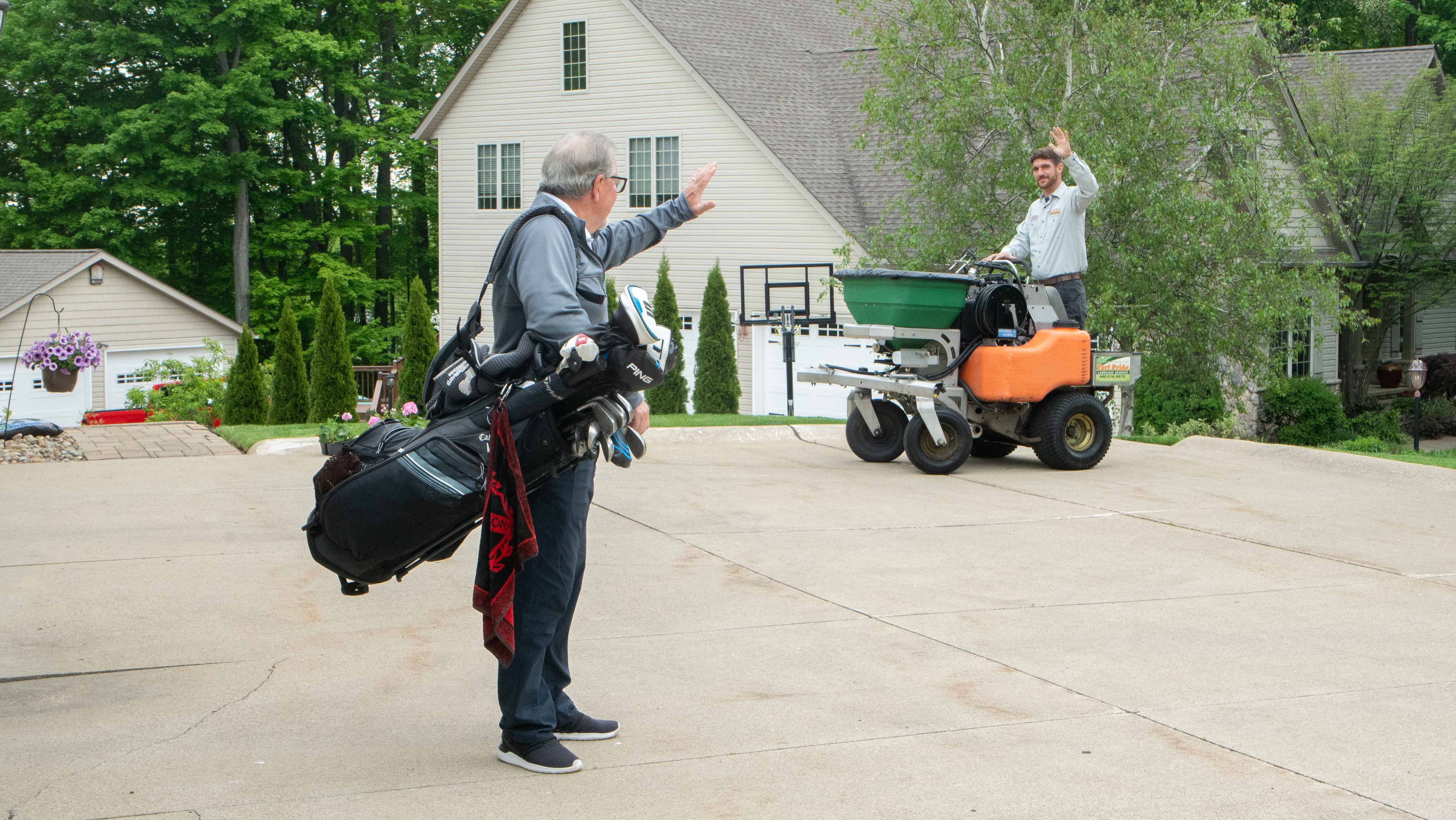 technician-waving-to-customer-golfing