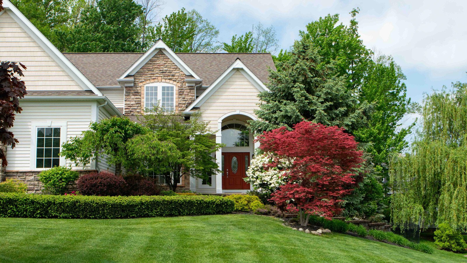 front of house with trees changing color 