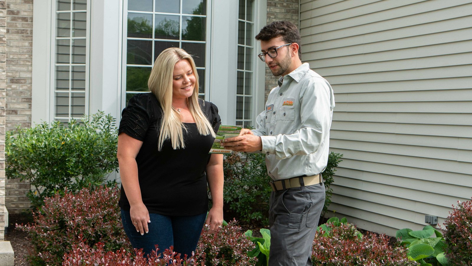 technician showing customer how to take care of lawn