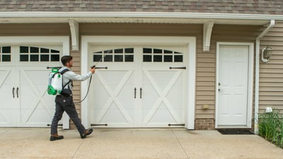 technician spraying the garage to keep pests out 