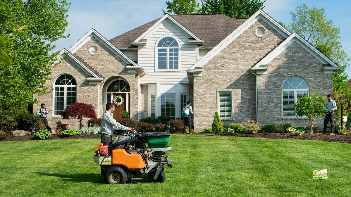 Lawn care technician fertilizing grass