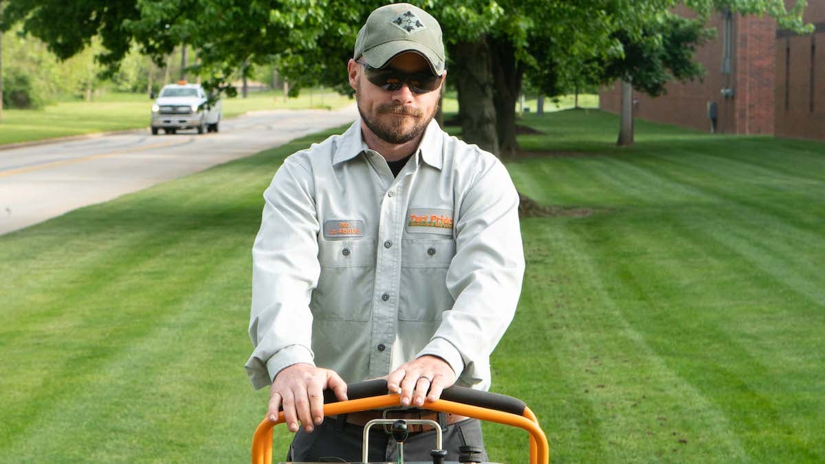 Technician riding aeration machine