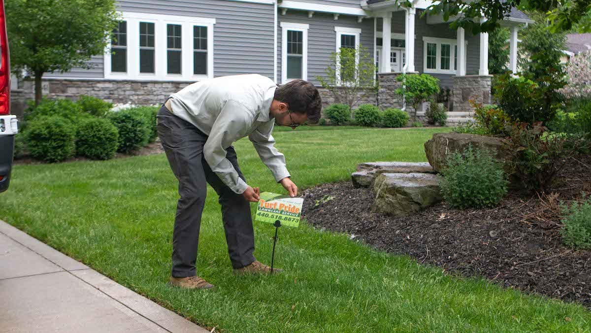 technician putting up lawn sign