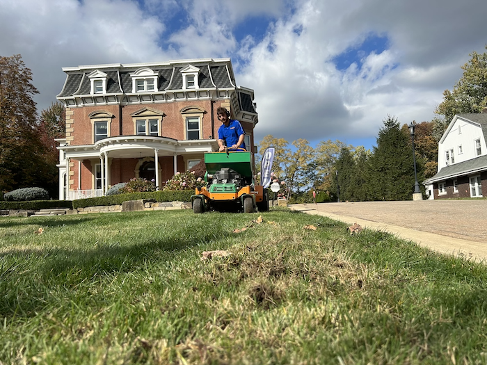 crew on machine aerating and overseeding lawn in fall