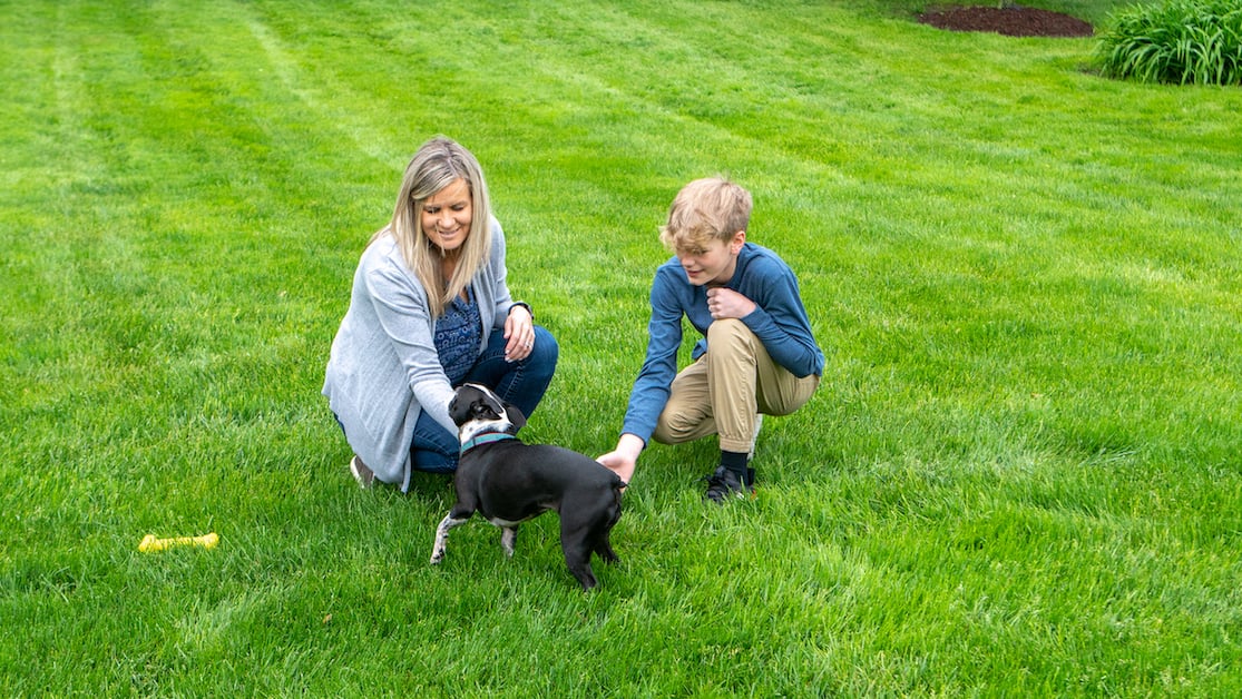 client playing in front lawn with child and dog 