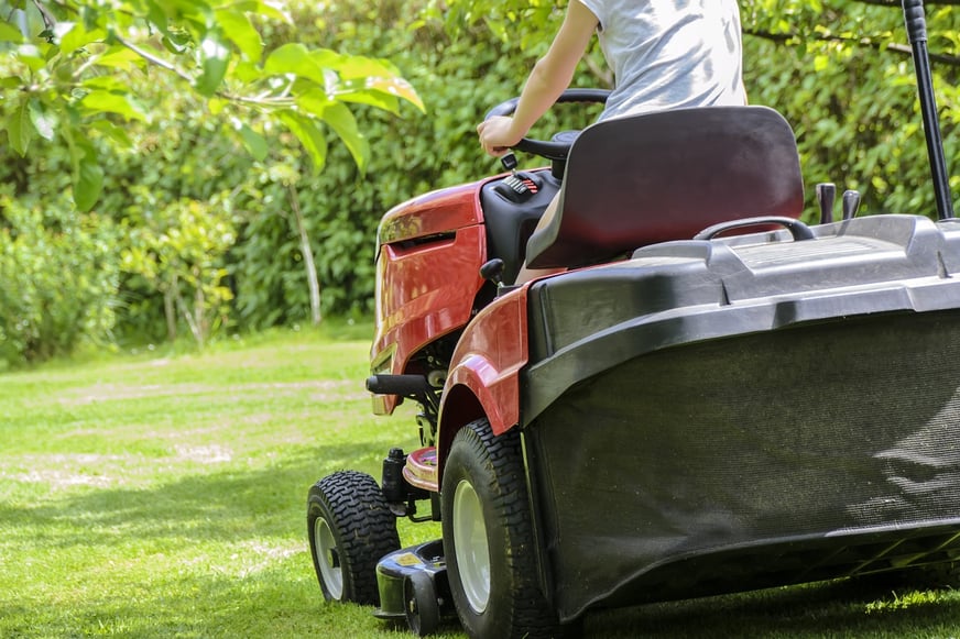 riding mower mowing lawn and collecting grass clippings