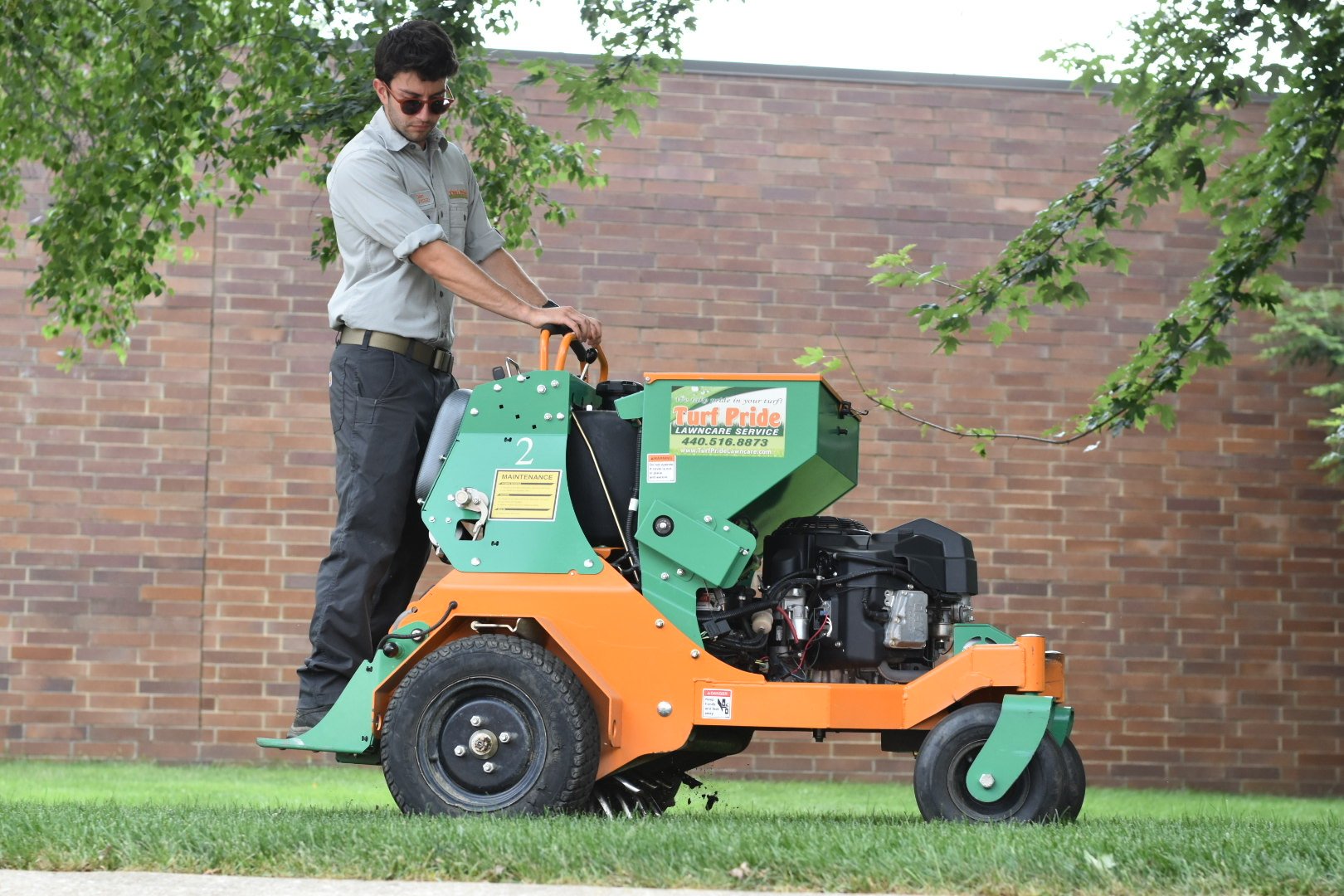 team member on machine aerating green lawn 2