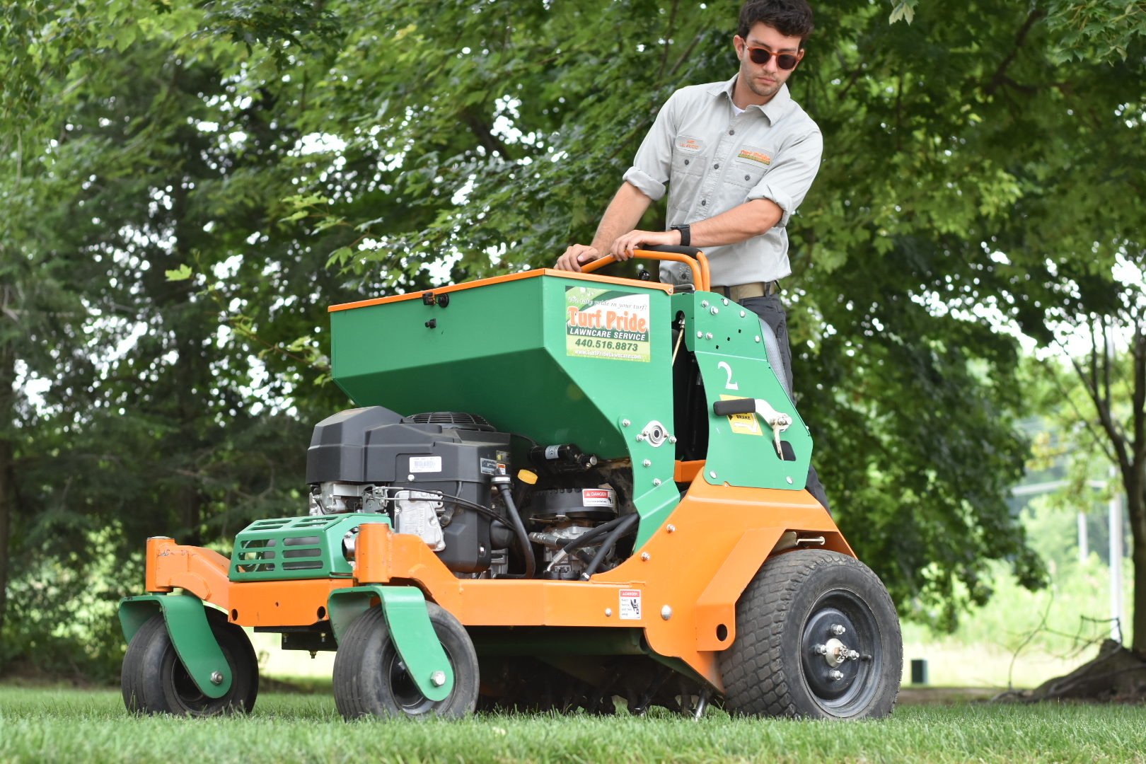 team member on machine aerating green lawn 4