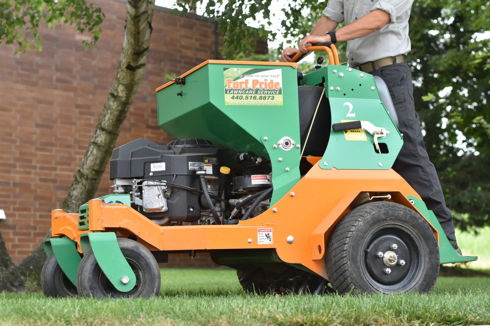 team member on machine aerating green lawn 7