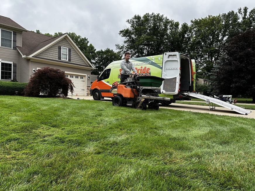 team member overseeding green lawn