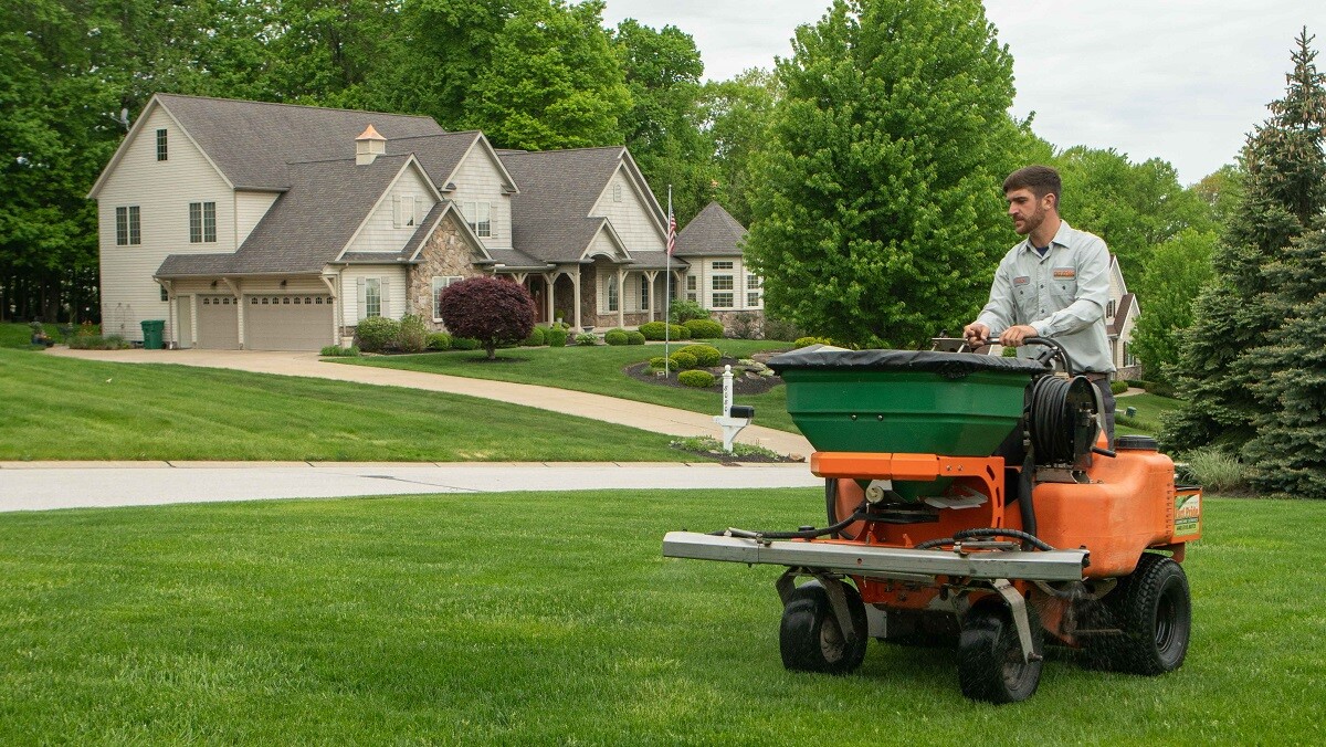 technician fertilizing in front yard with machine