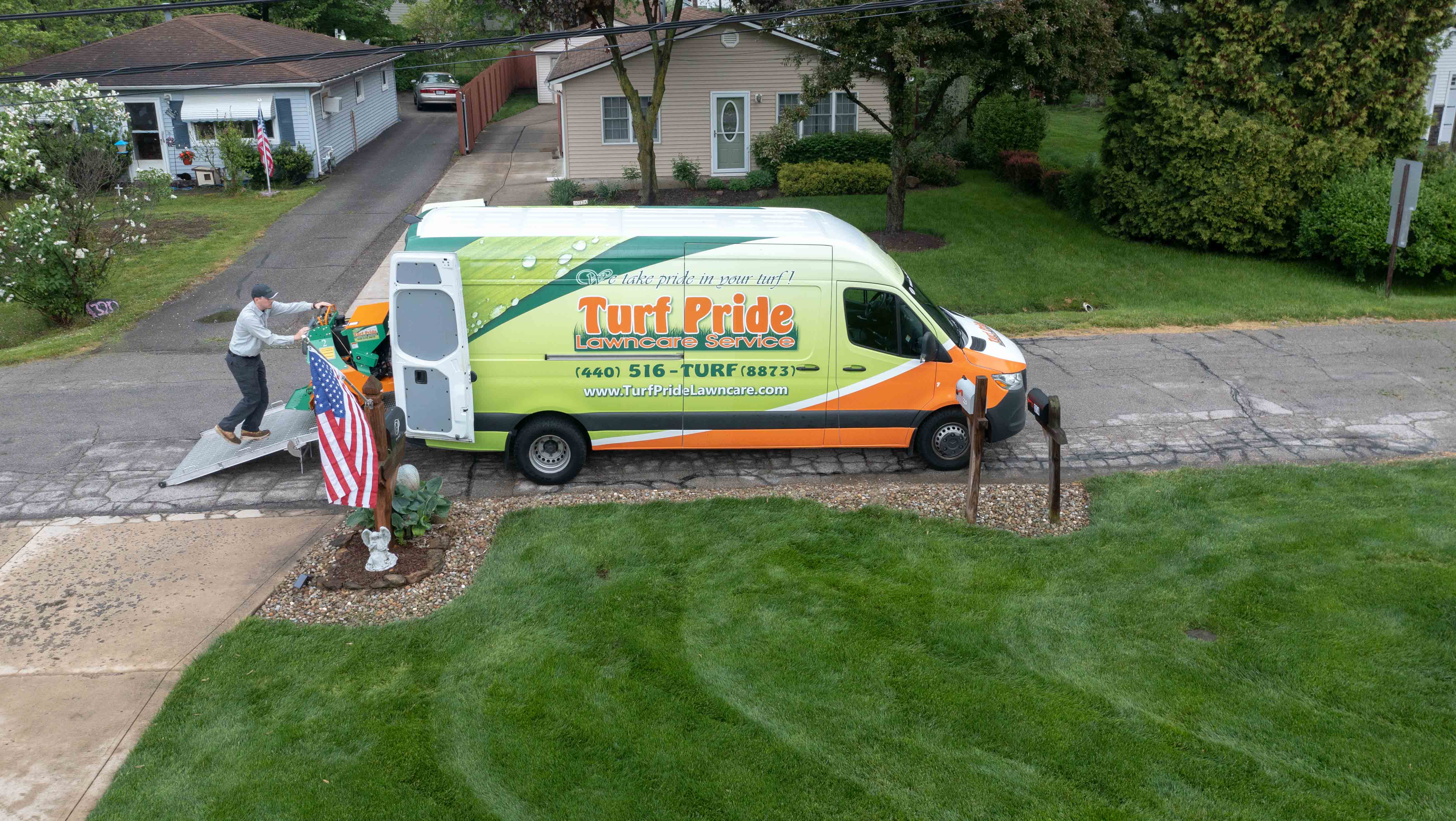 green grass and turf pride lawn care van near driveway 
