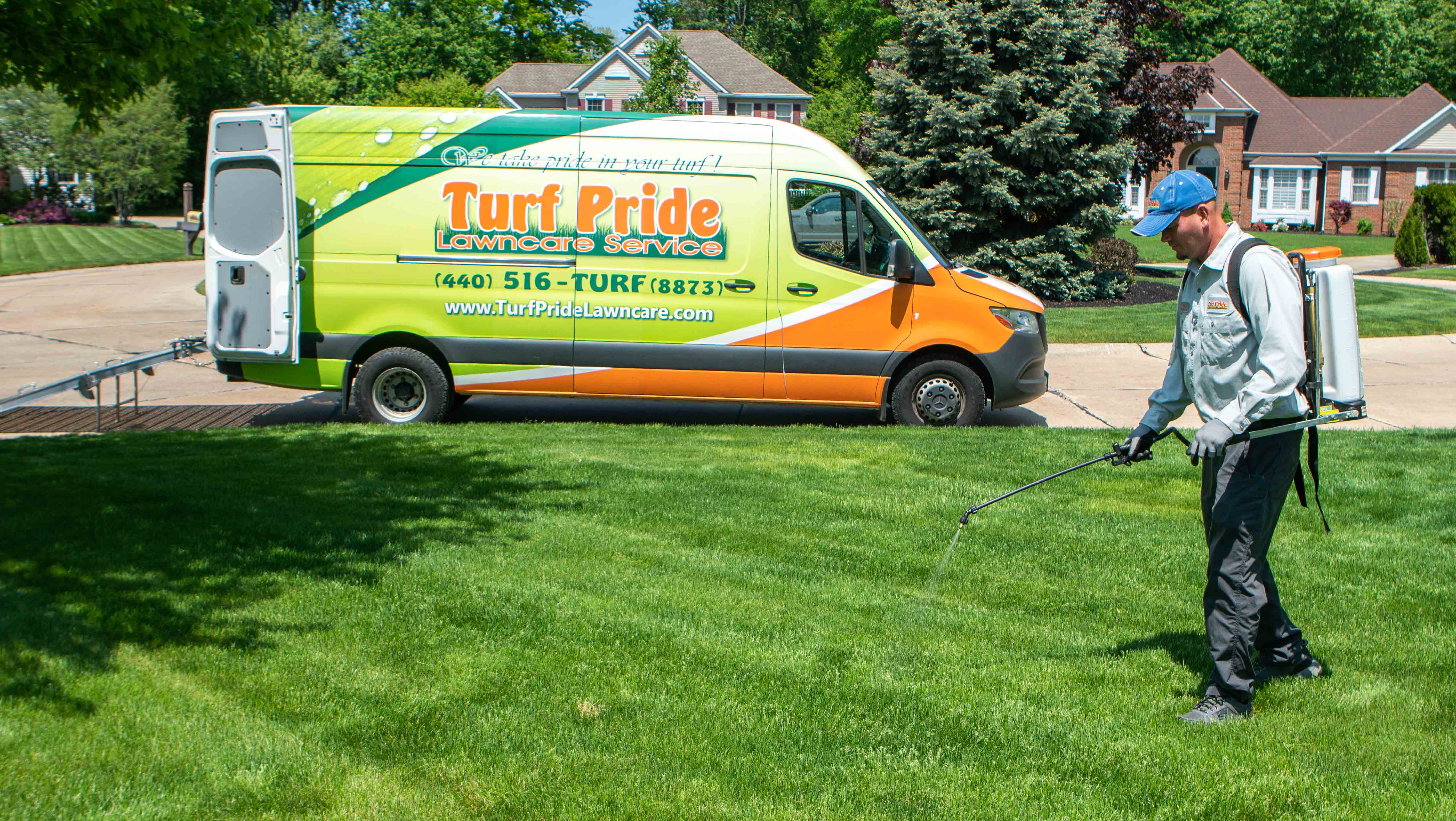 Lawn care technician applying weed control