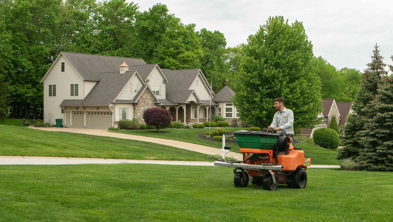 Lawn care on green lawn with house in background