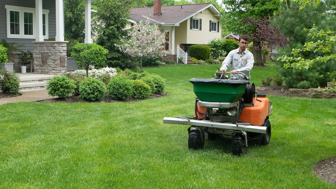 technician fertilizing lawn 
