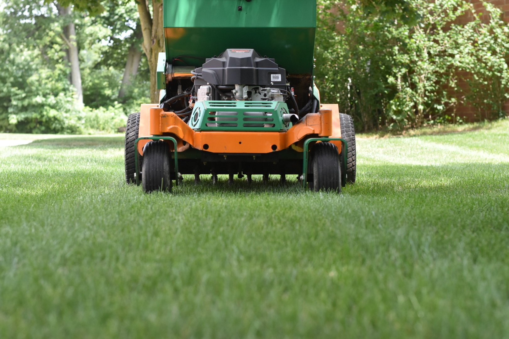 Machine on customer green lawn aerating 